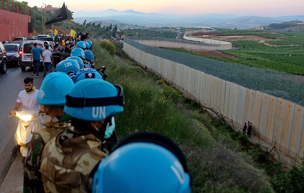 Des soldats de la force de maintien de la paix des Nations Unies au Liban se tiennent le long du mur frontalier avec Israël,  le 15 mai 2021. Photo par Mahmoud ZAYYAT /AFP via Getty Images.