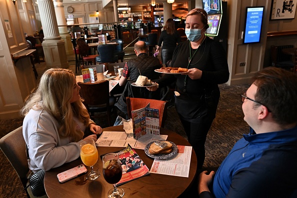 Un membre du personnel sert de la nourriture aux clients du pub à Liverpool, les restrictions de verrouillage s'atténuent dans tout le pays le 17 mai 2021. Photo de Paul ELLIS/AFP via Getty Images.