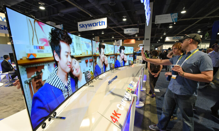 Des visiteurs regardent des téléviseurs OLED incurvés 4K Skyworth de 65 pouces exposés au CES international 2015 à Las Vegas, Nevada, le 8 janvier 2015. (Ethan Miller/Getty Images)