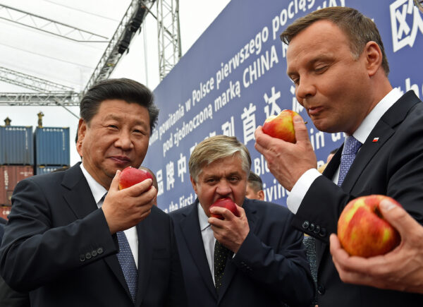 Le dirigeant chinois Xi Jinping (à g.) et le président polonais Andrzej Duda (à d.) mangent des pommes polonaises à l’occasion de l'arrivée à la capitale polonaise Varsovie du premier train de China Railway Express, le 20 juin 2016. (Janek Skarzynski/AFP via Getty Images)