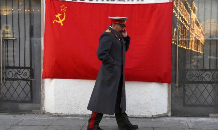 Un imitateur du dictateur soviétique Joseph Staline passe devant un drapeau rouge à marteau et faucille dans le centre de Moscou, le 21 novembre 2016. (Vasily Maximov/AFP via Getty Images)