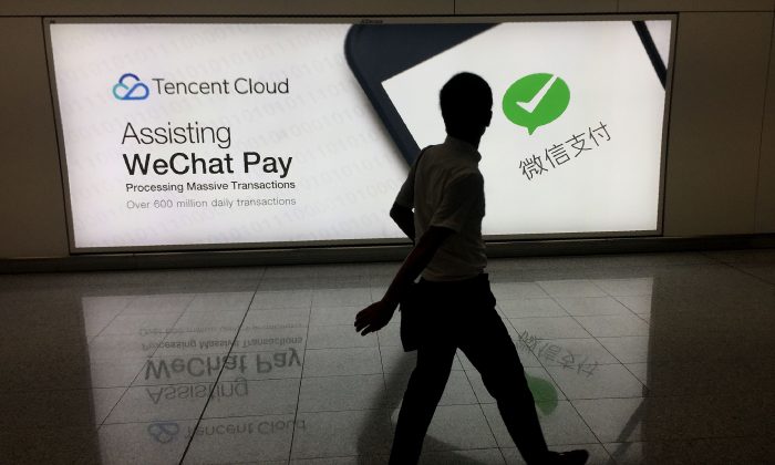 Un homme passe devant une publicité pour la plateforme de médias sociaux WeChat, détenue par Tencent, à l'aéroport international de Hong Kong, le 21 août 2017. (Richard A. Brooks/AFP/Getty Images)