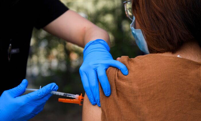Un adolescent de 15 ans reçoit une injection d'un vaccin contre le Covid-19 dans une clinique de vaccination mobile au Weingart East Los Angeles YMCA à Los Angeles, le 14 mai 2021. (Patrick T. Fallon/AFP via Getty Images)
