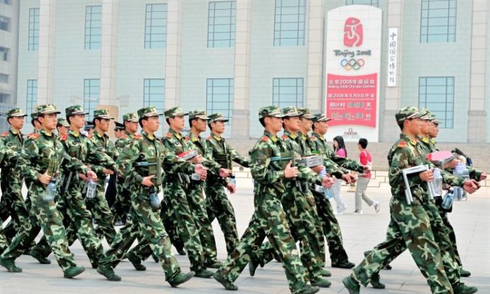 Des policiers paramilitaires chinois patrouillent devant l'horloge du compte à rebours des Jeux olympiques de Pékin, en bordure de la place Tiananmen, à Pékin, le 29 avril 2008. À l'approche des Jeux olympiques, le régime chinois a pris des mesures de répression contre les groupes considérés comme dissidents. (Teh Eng Koon/AFP/GETTY IMAGES)