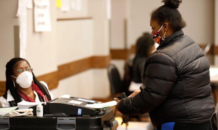 Une électrice américaine passe son bulletin de vote dans la tabulatrice après avoir voté lors de l'élection générale de 2020, sur une photo d'archives. (Jeff Kowalsky/AFP via Getty Images)