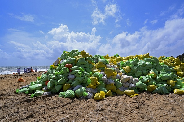 Des sacs contenant des débris rejetés sur le rivage du porte-conteneurs MV X-Press Pearl, immatriculé à Singapour, qui coule après avoir brûlé pendant près de deux semaines dans la mer au large du port de Colombo, sont photographiés sur une plage de Colombo le 10 juin 2021. (Photo : ISHARA S. KODIKARA/AFP via Getty Images)