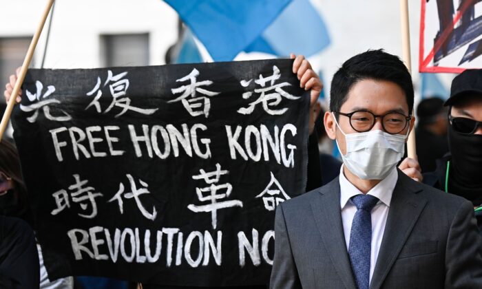 Nathan Law, militant pour la démocratie à Hong Kong, se tient à côté d'une bannière sur laquelle on peut lire "Free Hong Kong. Revolution now" alors qu'il participe à une manifestation devant le ministère des Affaires étrangères à Berlin, en Allemagne, le 1er septembre 2020. (Tobias Schwarz/AFP via Getty Images)
