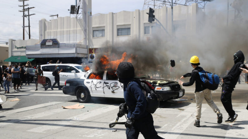 Un véhicule de police est incendié par des émeutiers à Los Angeles, en Californie, le 30 mai 2020. (Mario Tama/Getty Images)