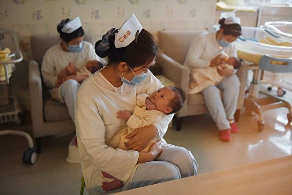 Des infirmières avec des bébés au centre Xiyuege à Pékin, le 13 décembre 2016. (Greg Baker/AFP via Getty Images)