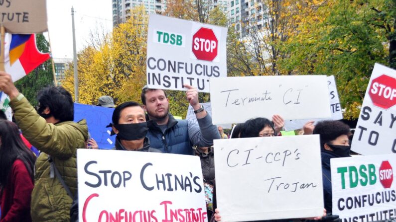 Des personnes manifestent contre le partenariat du Conseil scolaire du district de Toronto avec l'Institut Confucius, contrôlé par Pékin, devant le bureau du Conseil scolaire, à Toronto, Canada, le 29 octobre 2014. (Allen Zhou/The Epoch Times)