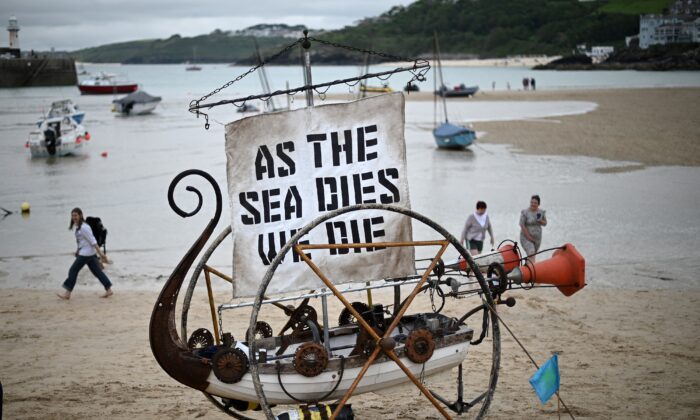 « Puisque l'océan se meurt, nous mourons » / 
Une sculpture de bateau présentée lors d'une manifestation contre le changement climatique sur la plage de St Ives, en Cornouailles, en Angleterre, pendant le sommet du G7, le 11 juin 2021. (Daniel Leal-Olivas/AFP via Getty Images)