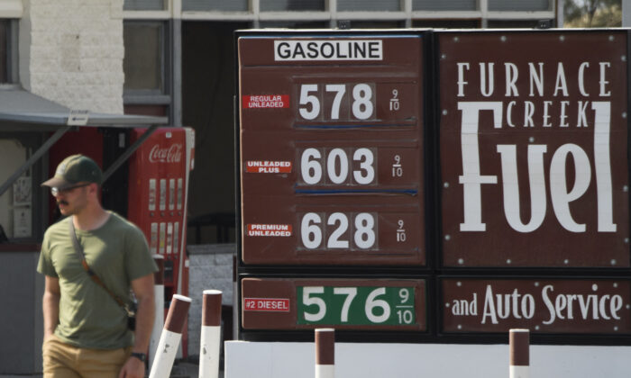 Un piéton passe devant une station-service dont le prix du carburant dépasse les 4 et 5 euros le gallon (1,115 et 1,339 euros le litre) au parc national de la Vallée de la Mort à Furnace Creek, en Californie, le 17 juin 2021. (Patrick T. Fallon/AFP via Getty Images)
