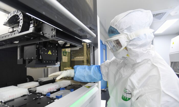 Un technicien travaille avec des échantillons de personnes à tester pour le virus du Covid-19 au laboratoire "Fire Eye" à Wuhan, le 6 février 2020. La BGI, une société de séquençage de l'ADN chinoise, a déclaré avoir ouvert, le 5 février, ce laboratoire capable de tester jusqu'à 10 000 personnes par jour. (STR/AFP via Getty Images)