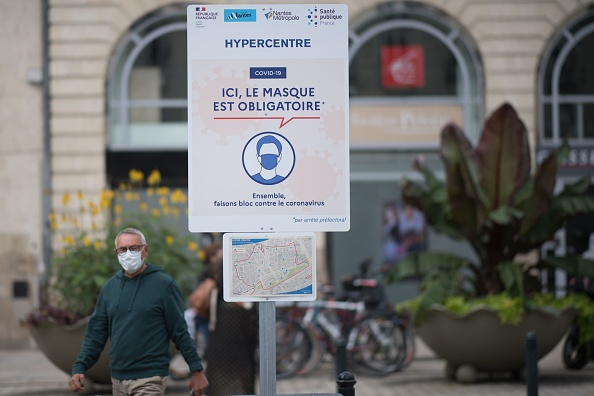 Un homme qui porte un masque à Nantes, dans l'ouest de la France, près d'une annonce indiquant que les masques sont obligatoires dans le centre et certaines zones de la ville, le 24 août 2020. (LOIC VENANCE/AFP via Getty Images) 