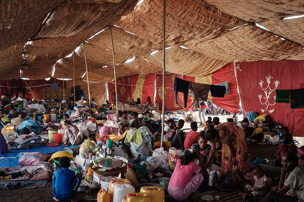 Des réfugiés qui ont fui le conflit du Tigré en Éthiopie reposent dans une tente de fortune au centre d'accueil frontalier de Hamdayit, dans l'est du Soudan. Photo de Yasuyoshi CHIBA / AFP via Getty Images.