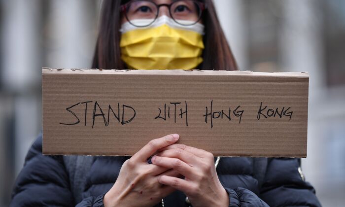 Une manifestante tient une petite pancarte lors d'un événement organisé par Justitia Hong Kong pour pleurer la perte des libertés politiques de Hong Kong, à Leicester Square, dans le centre de Londres, le 12 décembre 2020. (Justin Tallis/AFP via Getty Images)