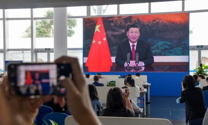 Des journalistes regardent un écran montrant le dirigeant chinois Xi Jinping prononçant un discours lors de l'ouverture de la conférence annuelle 2021 du Forum de Boao pour l'Asie (BFA) à Boao, dans la province de Hainan, en Chine, le 20 avril 2021. (STR/AFP via Getty Images)
