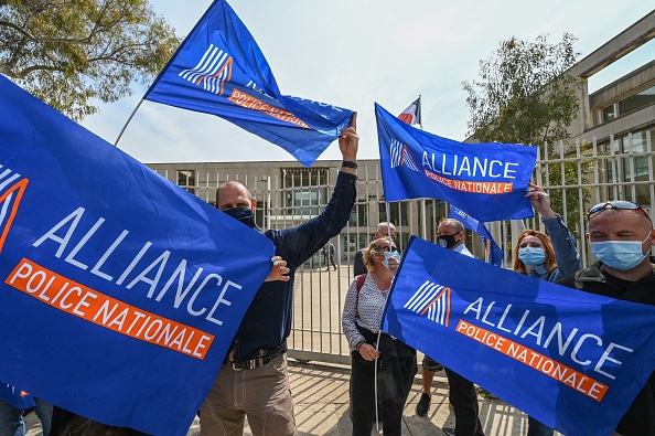 Des policiers tiennent des drapeaux lors d'une manifestation à l'appel du syndicat de la police nationale française Alliance PN, à Montpellier le 20 avril 2021.  (PASCAL GUYOT/AFP via Getty Images)