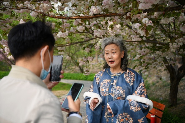 -L'influenceuse des médias sociaux, mamie Ruan Yaqing enregistre une courte vidéo pour sa chaîne sur les applications Douyin, la version chinoise de TikTok, dans un parc à Pékin. Photo de GREG BAKER/AFP via Getty Images.