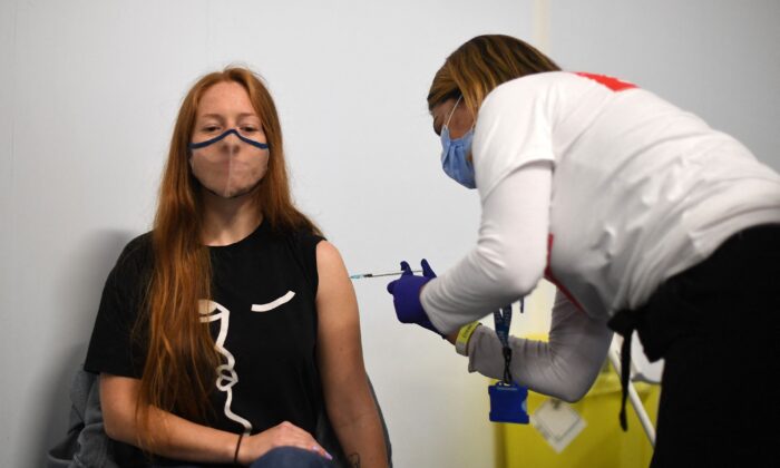 Les membres du public reçoivent une dose de vaccin Pfizer Covid-19 à l'intérieur d'un centre de vaccination temporaire installé à l'Emirates Stadium, siège du club de football d'Arsenal, dans le nord de Londres, le 25 juin 2021. (Daniel Leal-Olivas/AFP via Getty Images)