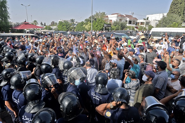 -Des agents de sécurité tunisiens retiennent des manifestants devant le bâtiment du parlement dans la capitale Tunis le 26 juillet 2021, à la suite d'une décision du président de suspendre le parlement du pays et de limoger le Premier ministre. Photo FETHI BELAID / AFP via Getty Images.