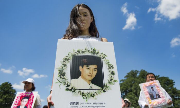 Des manifestants du Falun Gong tiennent des photos commémoratives alors qu'ils marchent sur le Capitole à Washington, le 17 juillet 2014. (Jim Watson/AFP via Getty Images)