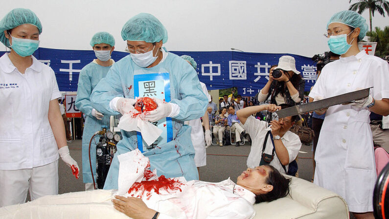 Au cours d'un rassemblement auquel se sont joints des milliers de pratiquants de Falun Gong à Taipei le 23 avril 2006, quatre manifestants simulent un prélèvement forcé d'organes dans des camps de concentration sur des pratiquants de Falun Gong par le Parti communiste chinois. (Crédit photo PATRICK LIN/AFP via Getty Images)