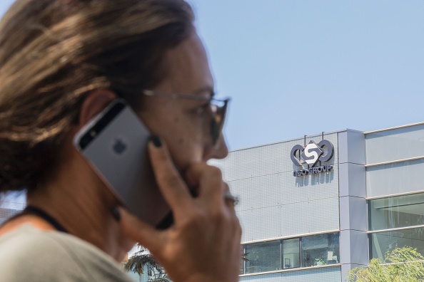 -Une Israélienne utilise son iPhone devant le bâtiment abritant le groupe israélien NSO, le 28 août 2016, à Herzliya, près de Tel Aviv. Photo de JACK GUEZ / AFP via Getty Images.