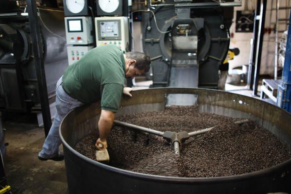 -Hernando Vasquez vérifie les grains qui coulent du torréfacteur avant qu'ils ne soient mis en sac chez Colonial Coffee. Photo par Joe Raedle/Getty Images.