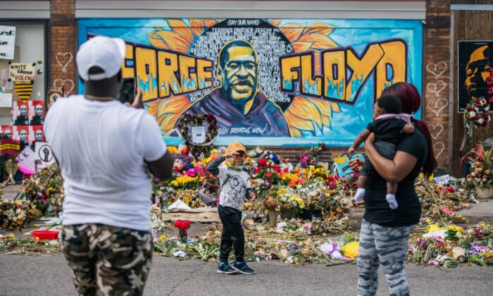 Une famille prend des photos devant une murale séparée de George Floyd à Minneapolis, Minnesota (États-Unis), le 28 mai 2020. La fresque ressemble à celle qui s'est effondrée le 13 juillet à Toledo, dans l'Ohio. (Brandon Bell/Getty Images)
