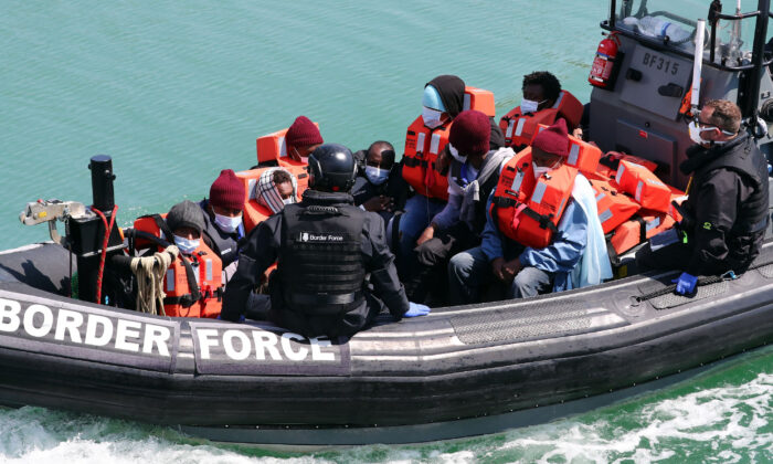 Un groupe de personnes soupçonnées d'être des immigrants illégaux est amené à Douvres, dans le Kent, à la suite d'un incident sur un petit bateau dans la Manche, le 6 juin 2021. (Gareth Fuller/PA) 