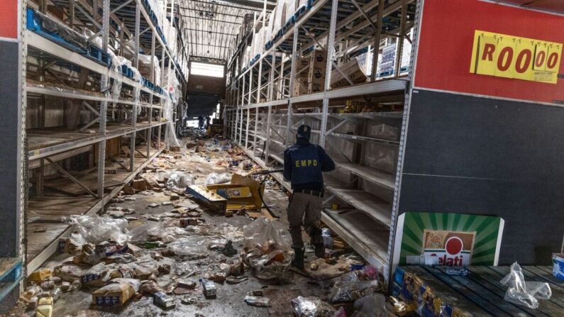 Un membre des services de police sud-africains recherche des voleurs à l'intérieur du centre commercial Gold Spot à Vosloorus, au sud-est de Johannesburg, le 12 juillet 2021. (Guillem Sartorio/AFP via Getty Images)
