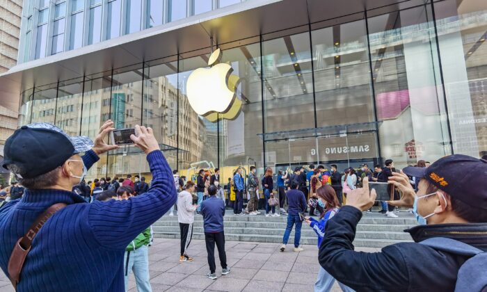 Des clients font la queue pour obtenir leur téléphone portable iPhone 12 réservé dans un magasin Apple à Shanghai, le 23 octobre 2020. (STR/AFP via Getty Images)