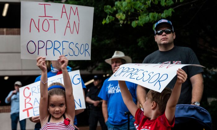 Des enfants brandissent des pancartes lors d'un rassemblement contre l'enseignement de la théorie critique de la race dans les écoles, au centre gouvernemental du comté de Loudoun à Leesburg, en Virginie, le 12 juin 2021. (Andrew Caballero-Reynolds/AFP via Getty Images)