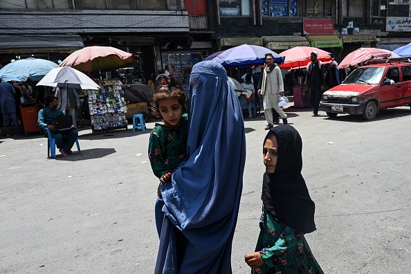 Une femme portant une burqa marche avec ses enfants sur un marché de Kaboul, le 21 juillet 2021.(Photo : SAJJAD HUSSAIN/AFP via Getty Images)