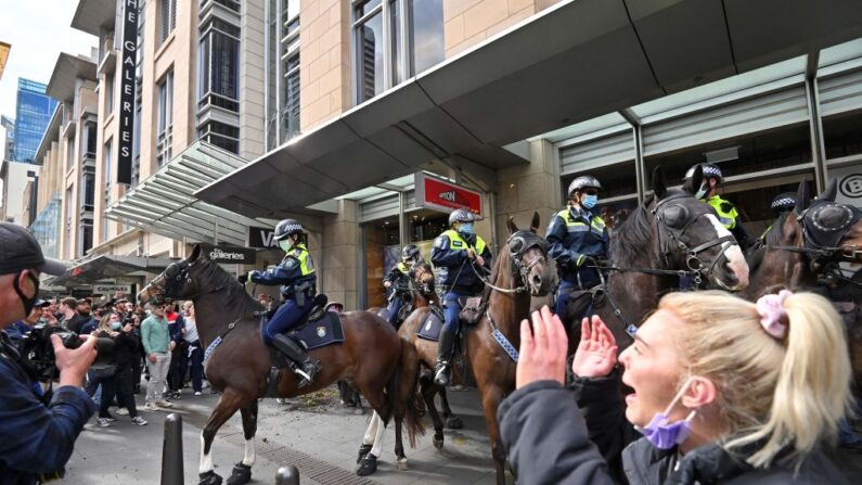 Des policiers à cheval dispersent des manifestants lors d'un rassemblement à Sydney, en Australie, le 24 juillet 2021, alors que des milliers de personnes se sont rassemblées pour manifester contre l'ordre de rester à la maison pour un mois, donné par la ville. (Steven Saphore/AFP via Getty Images)