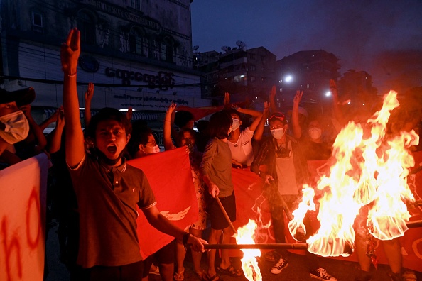 -Des manifestants brûlent des drapeaux birmans lors d'une manifestation contre le coup d'État militaire à Yangon le 29 juillet 2021. Photo de -/AFP via Getty Images.