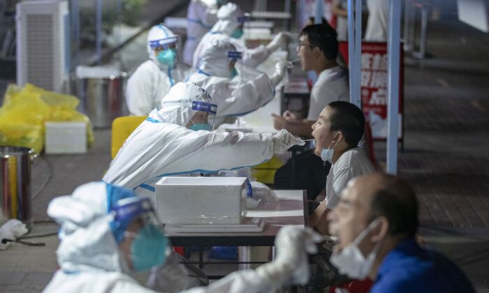 Des résidents reçoivent des tests d'acide nucléique pour le coronavirus à Wuhan, dans la province centrale chinoise du Hubei, le 3 août 2021. (STR/AFP via Getty Images)