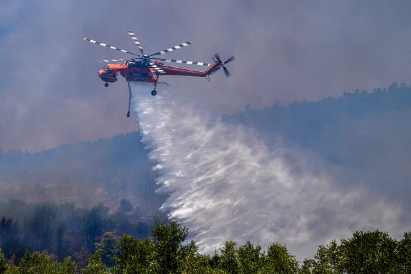 Un hélicoptère Sikorsky S-64 Skycrane largue de l'eau sur un nouvel incendie de forêt dans l'île d'Eubée. Photo par STR/Eurokinissi /AFP via Getty Images.