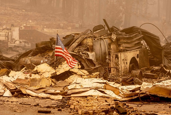 -Un drapeau américain est placé sur un camion de pompiers brûlé dans une caserne de pompiers du centre-ville de Greenville, en Californie, le 7 août 2021. Photo de JOSH EDELSON / AFP via Getty Images.