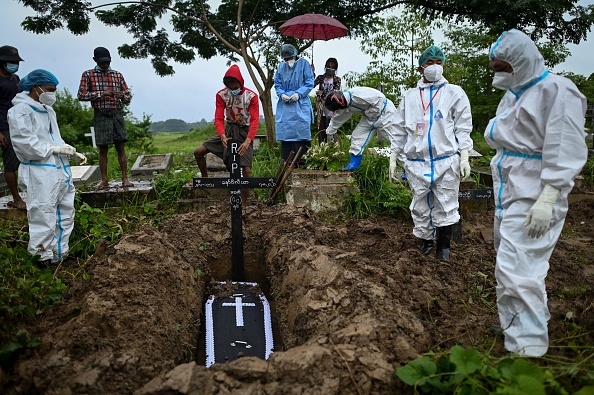 -Une équipe soudée de volontaires travaille sans relâche pour traiter, enterrer et incinérer les victimes du coronavirus est confrontée à la stigmatisation de leurs familles, en Birmanie, le 7 août 2021. Photo Ye Aung Thu / AFP via Getty Images.