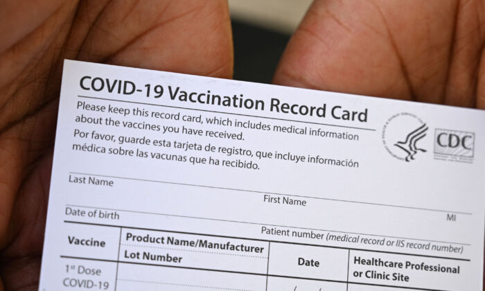 Un professionnel de la santé présente un carnet de vaccination Covid-19 d'une clinique de vaccination et de santé au QueensCare Health Center dans un quartier à prédominance latino de Los Angeles, en Californie, le 11 août 2021. (Robyn Beck/AFP via Getty Images)