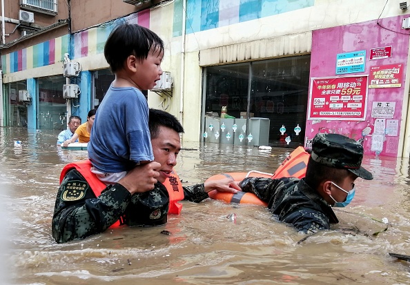 -Des sauveteurs évacuent un enfant d'une zone inondée à la suite de fortes pluies à Suizhou, dans la province centrale du Hubei en Chine. Photo de -/CNS/AFP via Getty Images.