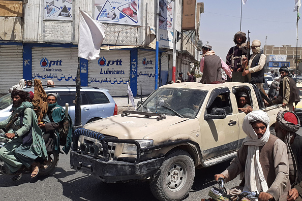 -Des combattants talibans conduisent un véhicule de l'armée nationale afghane dans une rue de Kandahar le 13 août 2021. Photo de -/AFP via Getty Images.