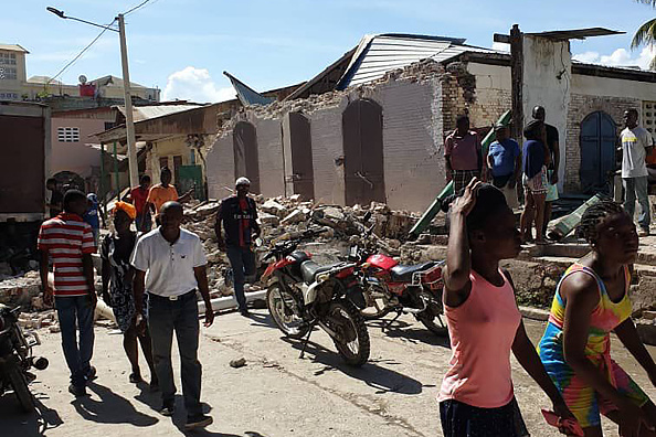 -Les gens regardent des maisons détruites après un tremblement de terre le 14 août 2021 à Jérémie, dans le sud-ouest d'Haïti. Photo de Tamas JEAN PIERRE / AFP via Getty Images.
