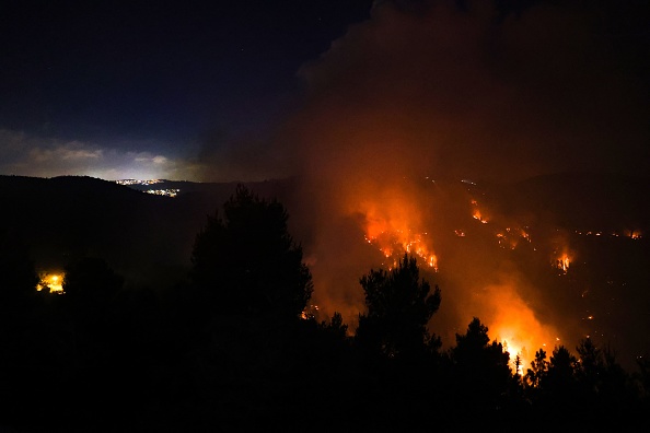 -Une épaisse fumée et des flammes s'élèvent d'un incendie de forêt sur les montagnes de Jérusalem près du village israélien de Moshav Shoresh, le 15 août 2021. Photo de Menahem KAHANA / AFP via Getty Images.