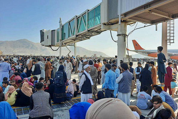 Des Afghans se pressent sur le tarmac de l'aéroport de Kaboul le 16 août 2021 pour fuir le pays alors que les talibans contrôlent l'Afghanistan. Photo de -/AFP via Getty Images.