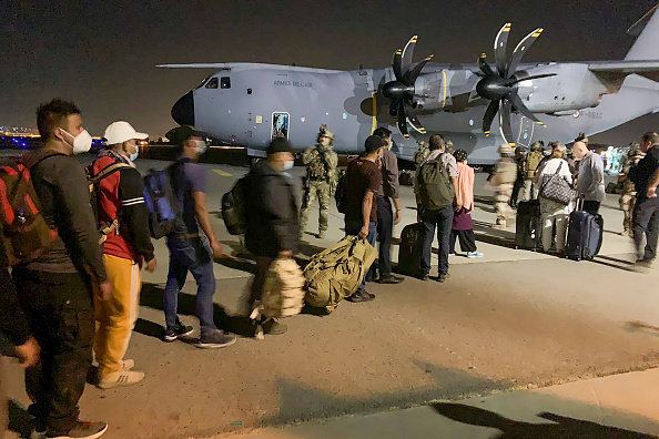 -Des ressortissants français et afghans font la queue pour embarquer à bord d'un avion de transport militaire français à l'aéroport de Kaboul le 17 août 2021. Photo par STR/AFP via Getty Images.