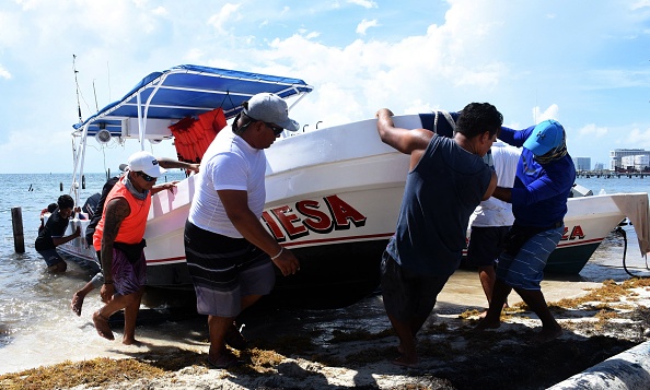 -Les pêcheurs et les voyagistes sortent leurs bateaux de la mer sur la plage de Puerto Juarez, au Mexique avant l'arrivée de l'ouragan Grace sur la côte de la Riviera Maya, le 18 août 2021. Photo d'ELIZABETH RUIZ / AFP via Getty Images.