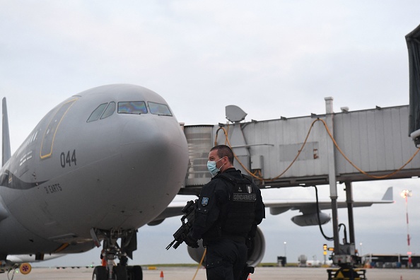 -Un gendarme français monte la garde devant l'Airbus A330 de l'armée de l'air française sur le tarmac après que des passagers, qui ont fui l'Afghanistan, débarquent à l'aéroport de Roissy Charles-de-Gaulle, le 18 août 2021. Photo par Alain JOCARD / AFP via Getty Images.